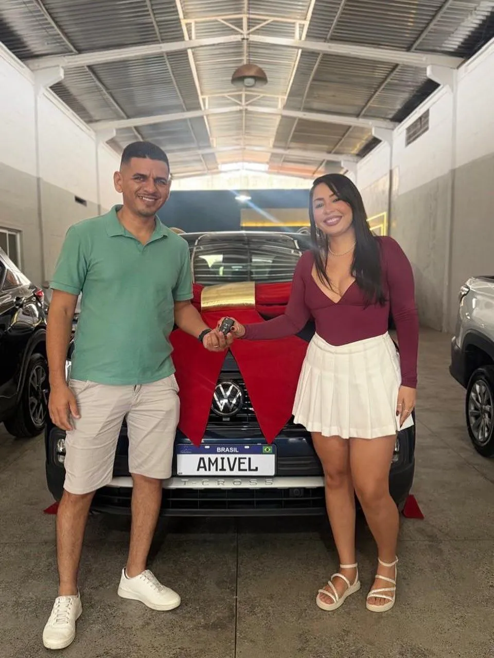 Clientes recebendo a chave do carro novo na Amivel